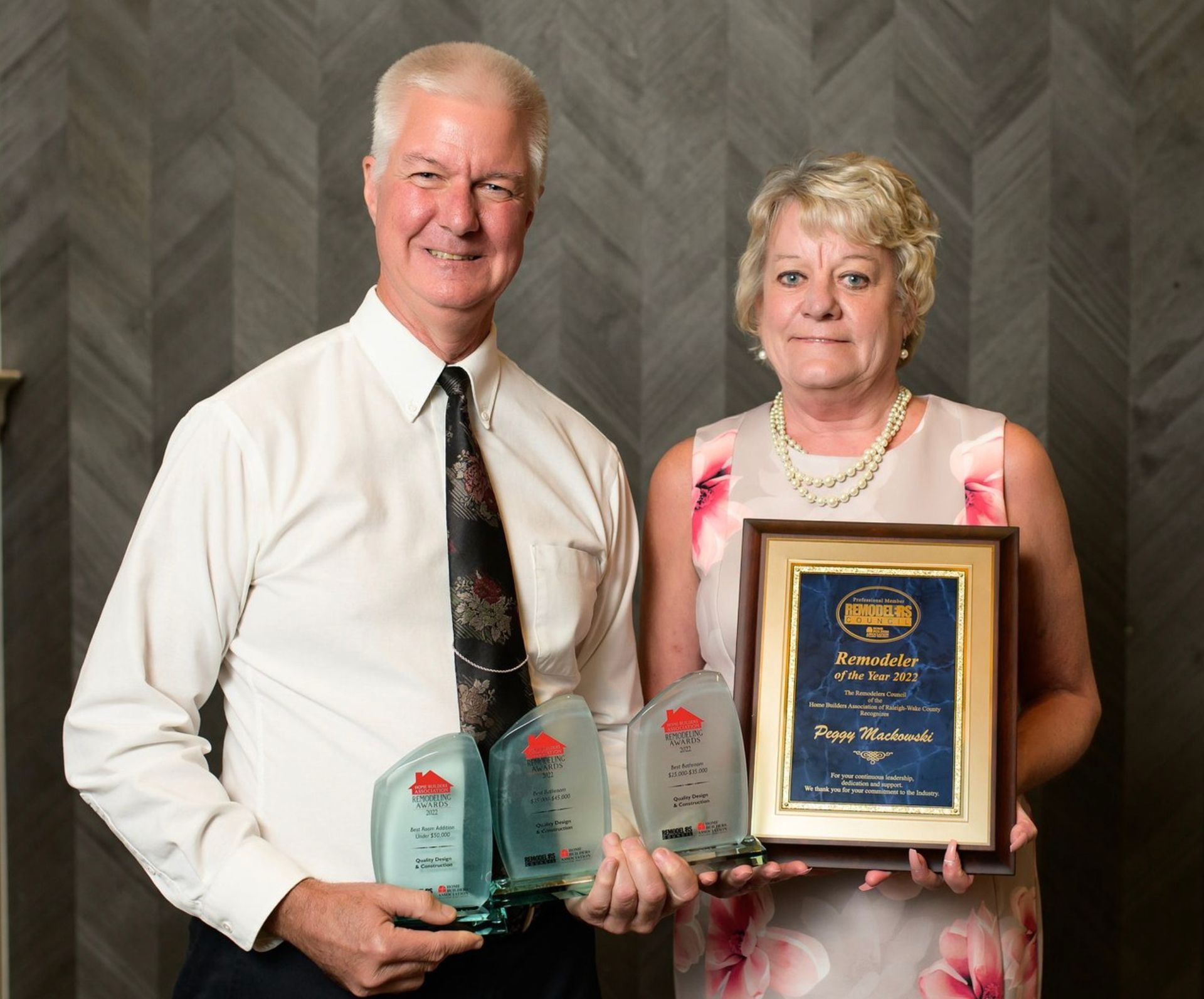 Dave and Peggy Mackowski holding Home Builders Association remodeling awards
