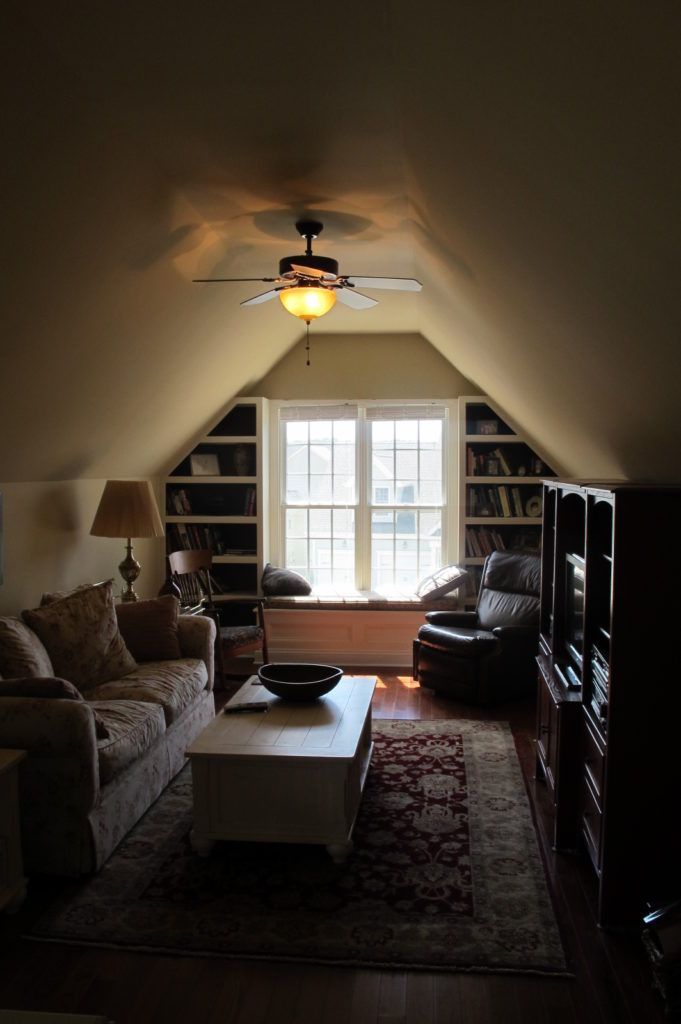 Finished attic quilting studio with fitted cabinetry and a design wall