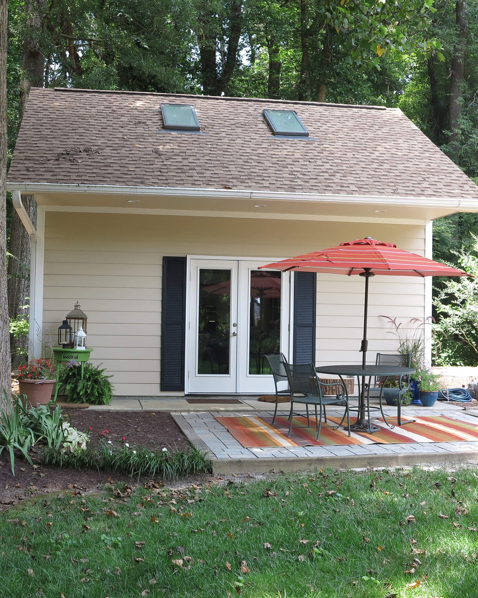 Custom built she shed in a garden with windows and a pitched roof